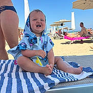 Sofia joined the competition — help win amazing prizes! baby, beach, towel, child, sunshine, smile, umbrella, sand, lounge_chair, summer, vacation, outdoor, people, blue_sky, happy, clothing, barefoot, holiday, relaxation, waterfront