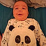 baby, infant, smiling, panda, onesie, plush_toy, bed, blanket, sleepwear, cute, child, portrait, happy, face, clothing, indoors, cozy, soft_toy, lying_down, toddler