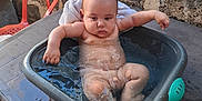 Kénaï participe au concours pour gagner de l'argent avec cette photo : arms, baby, bath, child, expression, face, infant, legs, naked, orange_chair, outdoor, plastic_tub, reflection, sitting, skin, stone_wall, table, tub, water, wet