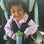 Braeleigh is registered to the contest to win money with this photo: toddler, child, car_seat, sippy_cup, curly_hair, smiling, happy, pink_jacket, black_pants, seatbelt, car_interior, babytrend, cartoon, drinkware, safety, cute, young_child, portrait, casual, daylight