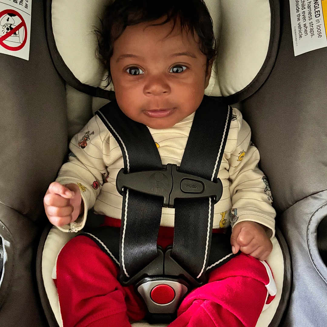 Yahmari is registered to the contest to win money with this photo: baby, bodypart, car, car_interior, carseat, clothing, coat, cushion, face, finger, hand, head, homedecor, jacket, pants, person, photography, portrait, transportation, vehicle