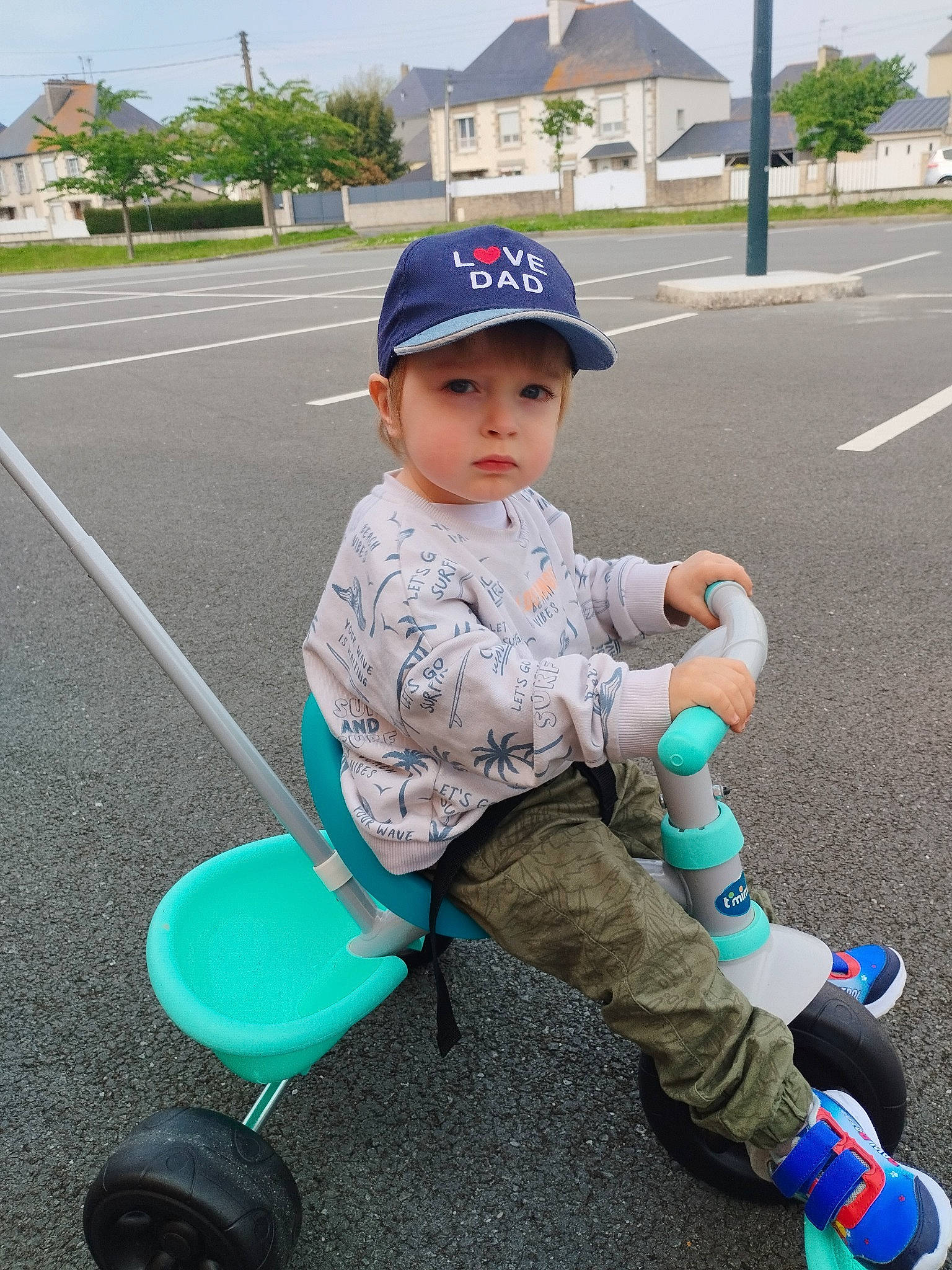 Jack participe au concours pour gagner de l'argent avec cette photo : asphalt, baby_toddler_clothing, baseball_cap, cap, child, electric_blue, fun, grass, hat, headwear, leisure, person, plant, product, recreation, rolling, sitting, sky, tire, toddler