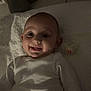 Juliette a rejoint le concours — aidez-le/la à gagner de superbes lots ! baby, child, cute, dim_lighting, expression, face, happy, head, indoors, infant, lying_down, pacifier, portrait, skin, small_teeth, smiling, soft_texture, towel, white_clothing, young