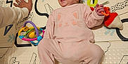 Juliette a rejoint le concours — aidez-le/la à gagner de superbes lots ! baby, cat_design, child, colorful, cozy, cute, family, floor, hand, happy, indoor, infant, lying_down, person, pink_onesie, play_mat, playtime, smiling, soft_toys, toys