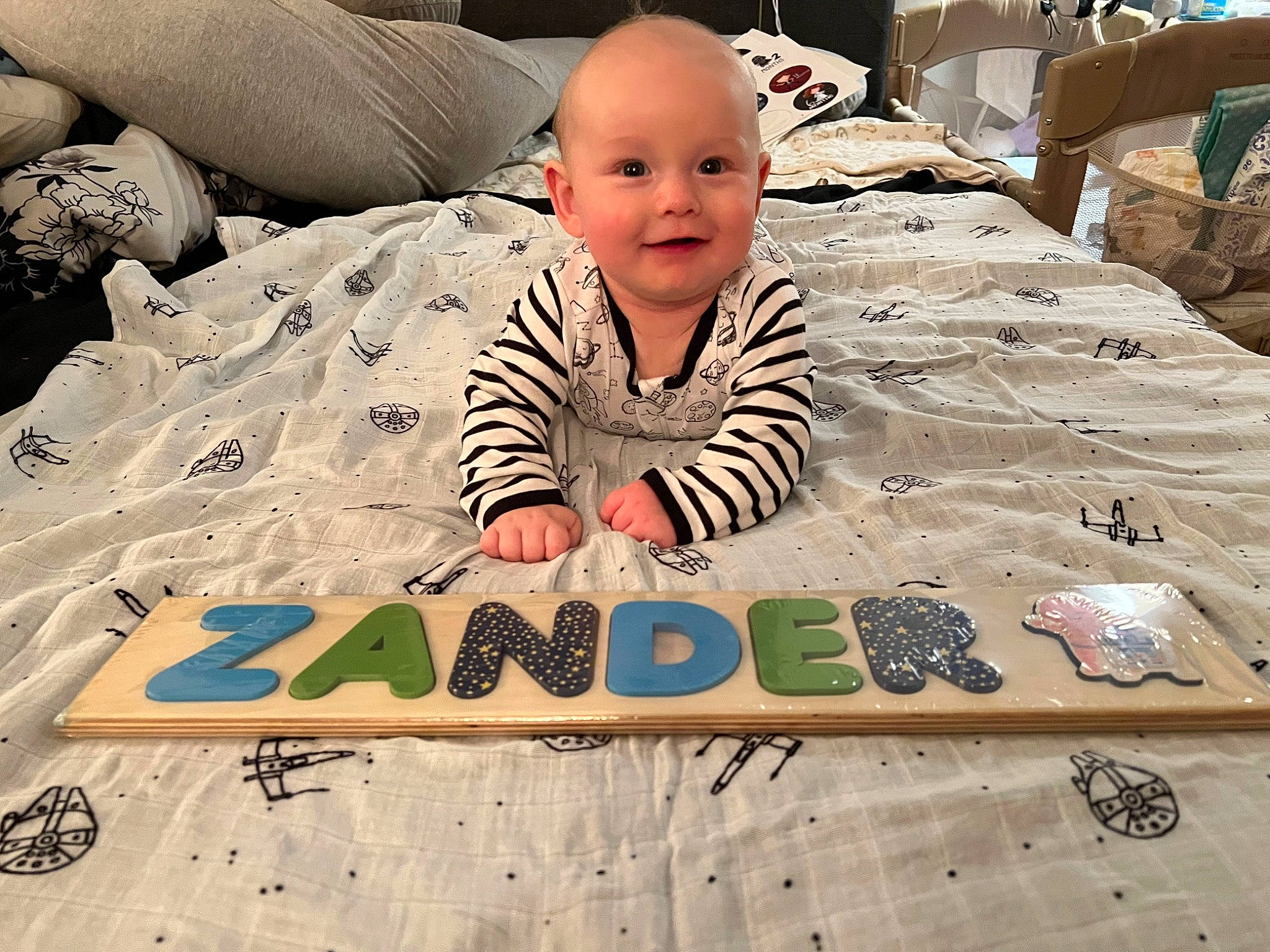 Zander is registered to the contest to win money with this photo: baby, baby_toddler_clothing, child, comfort, cool, crawling, eye, flooring, fun, happy, joy, leisure, linens, pattern, person, recreation, sitting, smile, t_shirt, toddler