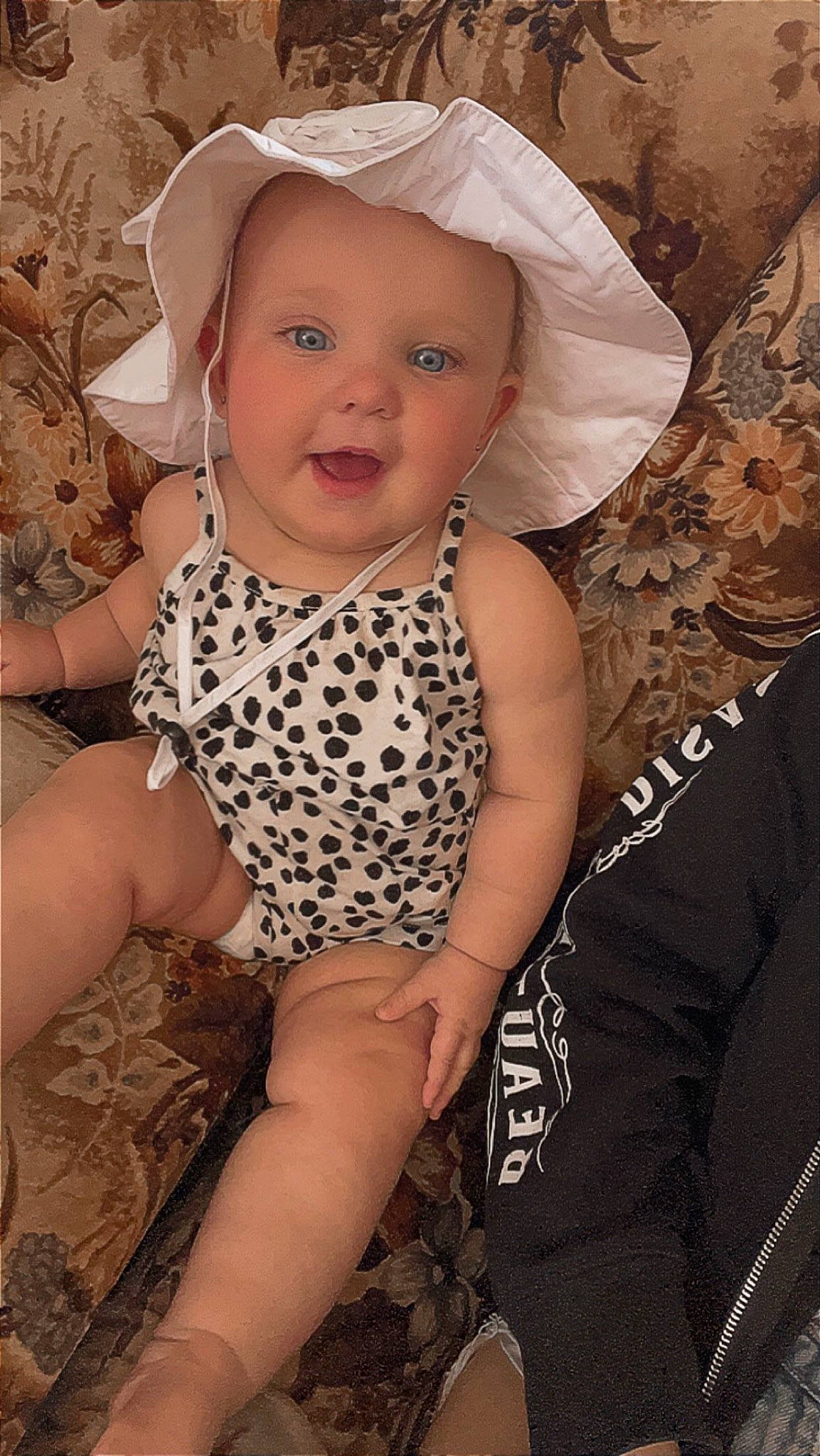 Brylee joined the competition — help win amazing prizes! baby, baby_products, baby_toddler_clothing, chest, child, eye, eyelash, face, happy, headgear, human_leg, nail, pattern, person, sitting, skin, smile, sun_hat, thigh, toddler