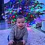 Austin joined the competition — help win amazing prizes! baby, child, christmas_tree, holiday_lights, presents, rug, sweater, indoor, smiling, festive, decorations, happy, toy, seasonal, home, celebration, cute, warm_clothing, floor, candid