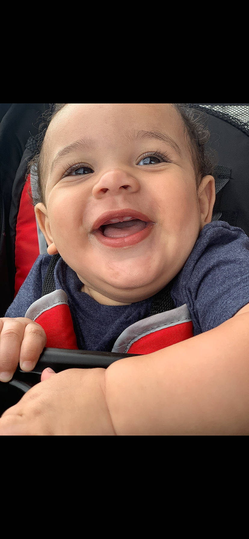 Amias is registered to the contest to win money with this photo: baby, car_seat, cheek, child, chin, eye, face, facial_expression, finger, hand, head, laugh, lip, mouth, nose, person, seat_belt, skin, smile, toddler