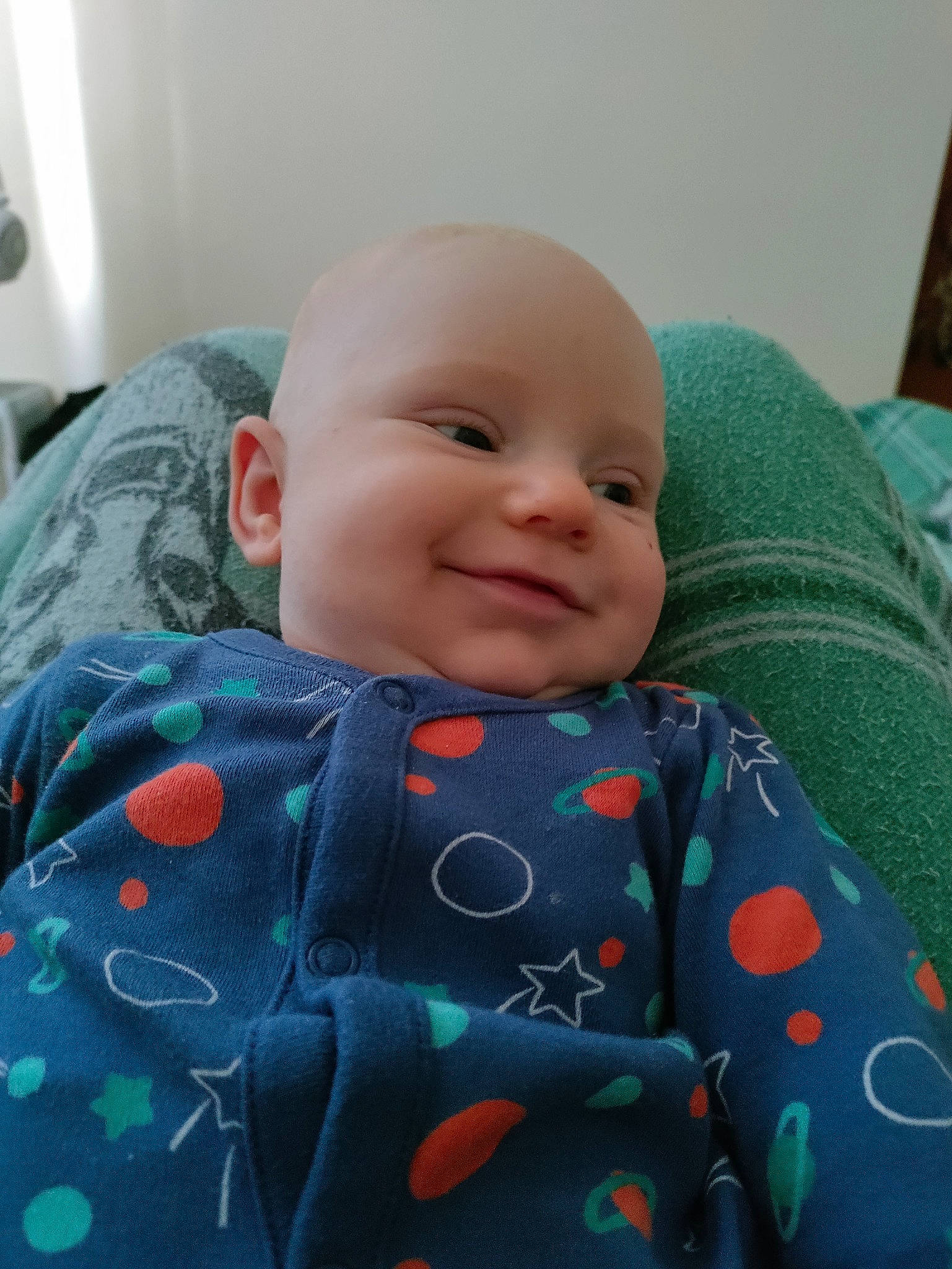 Sonny is registered to the contest to win money with this photo: baby, baby_toddler_clothing, cheek, child, chin, comfort, face, happy, iris, linens, mammal, nose, outerwear, person, room, sitting, skin, sleeve, smile, t_shirt