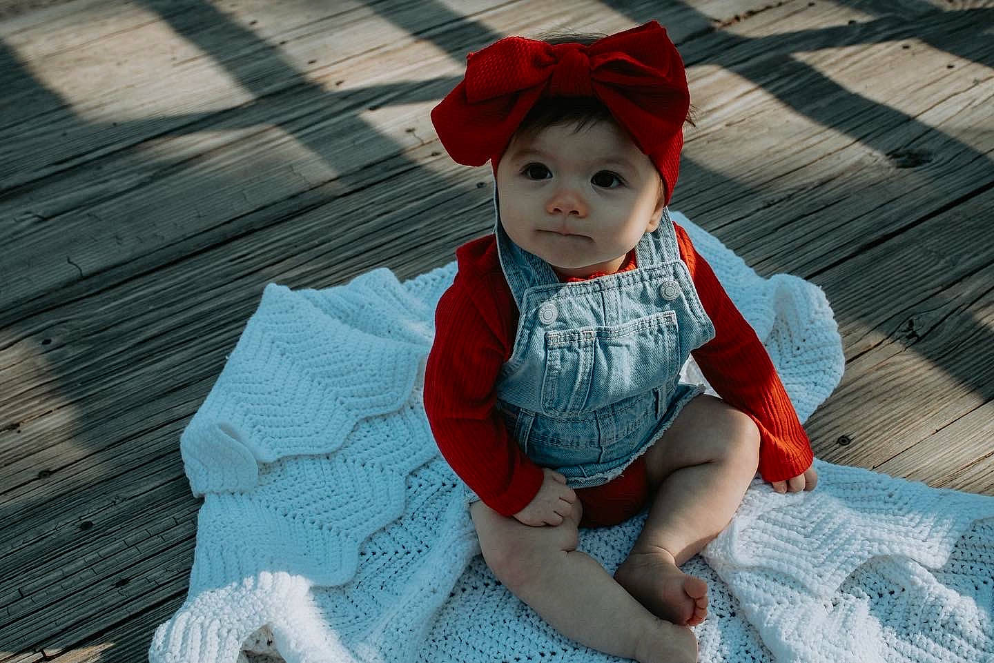 Evie joined the competition — help win amazing prizes! baby, baby_toddler_clothing, cap, carmine, child, dress, fashion_accessory, flooring, fun, grass, happy, hat, headwear, leisure, pattern, person, sitting, skin, sleeve, sun_hat