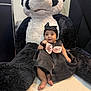 baby, child, plush, panda, stuffed_animal, black_dress, headband, pink_bow, bracelet, cute, indoor, floor, seated, portrait, infant, toy, soft_toy, comfort, happy, adorable