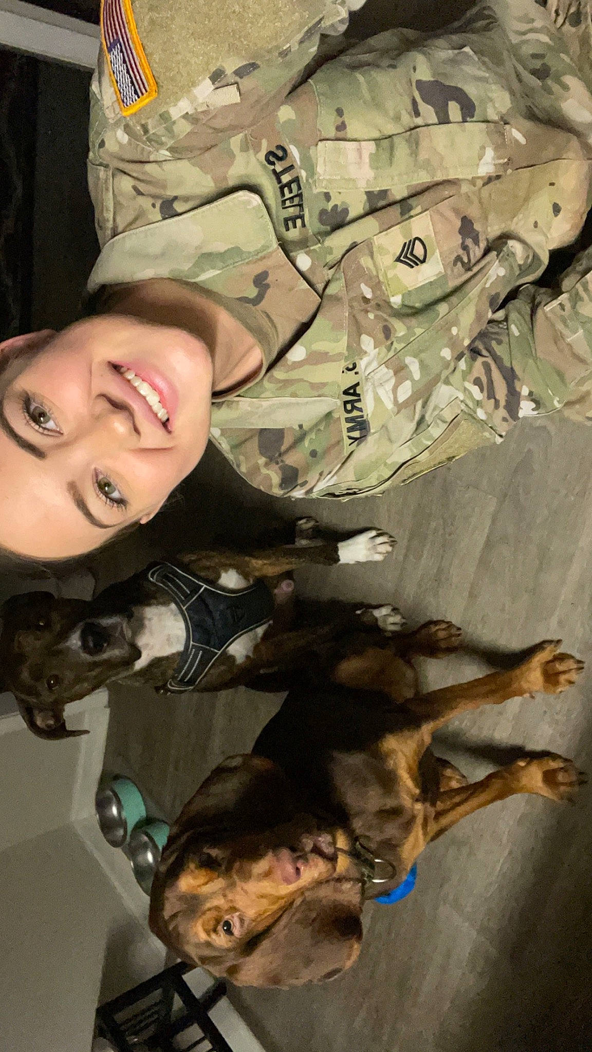 Lady is registered to the contest to win money with this photo: army, camouflage, carnivore, companion_dog, dog, dog_breed, fawn, fur, guard_dog, marines, military_camouflage, military_organization, military_person, military_uniform, non_commissioned_officer, pattern, smile, soldier, uniform, working_animal