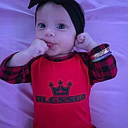 Tehani is registered to the contest to win money with this photo: baby, bow, bracelets, child, comfortable, cute, expression, eyes, face, hand_in_mouth, headband, infant, lying_down, plaid, portrait, purple_blanket, red_clothing, sleeves, soft, young