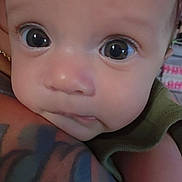 Tehani is registered to the contest to win money with this photo: baby, close_up, face, eyes, infant, tattoo, arm, skin, portrait, cute, child, expression, person, human, young, adorable, curious, resting, intimate, tender