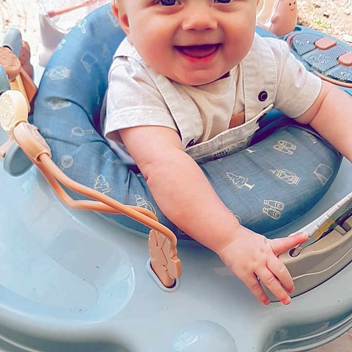 Cedar joined the competition — help win amazing prizes! baby, blue, bright, child, clothing, cute, expression, face, hands, happy, infant, outdoor, person, play, seat, sitting, smiling, toy, walker, young