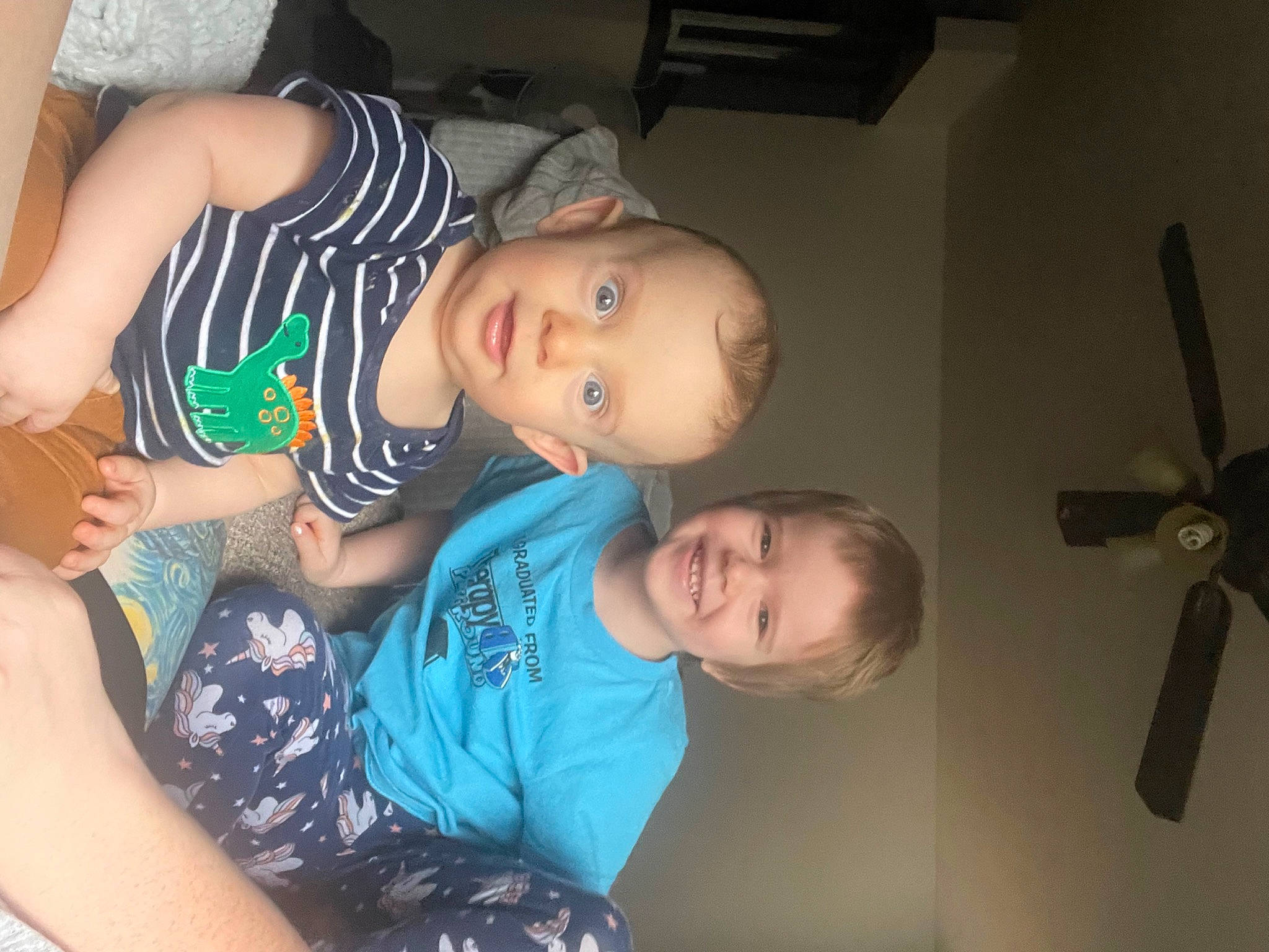 William is registered to the contest to win money with this photo: arm, baby, baby_toddler_clothing, ceiling_fan, cheek, chest, child, elbow, eye, fun, hairstyle, happy, joy, mechanical_fan, mouth, person, skin, smile, t_shirt, thigh