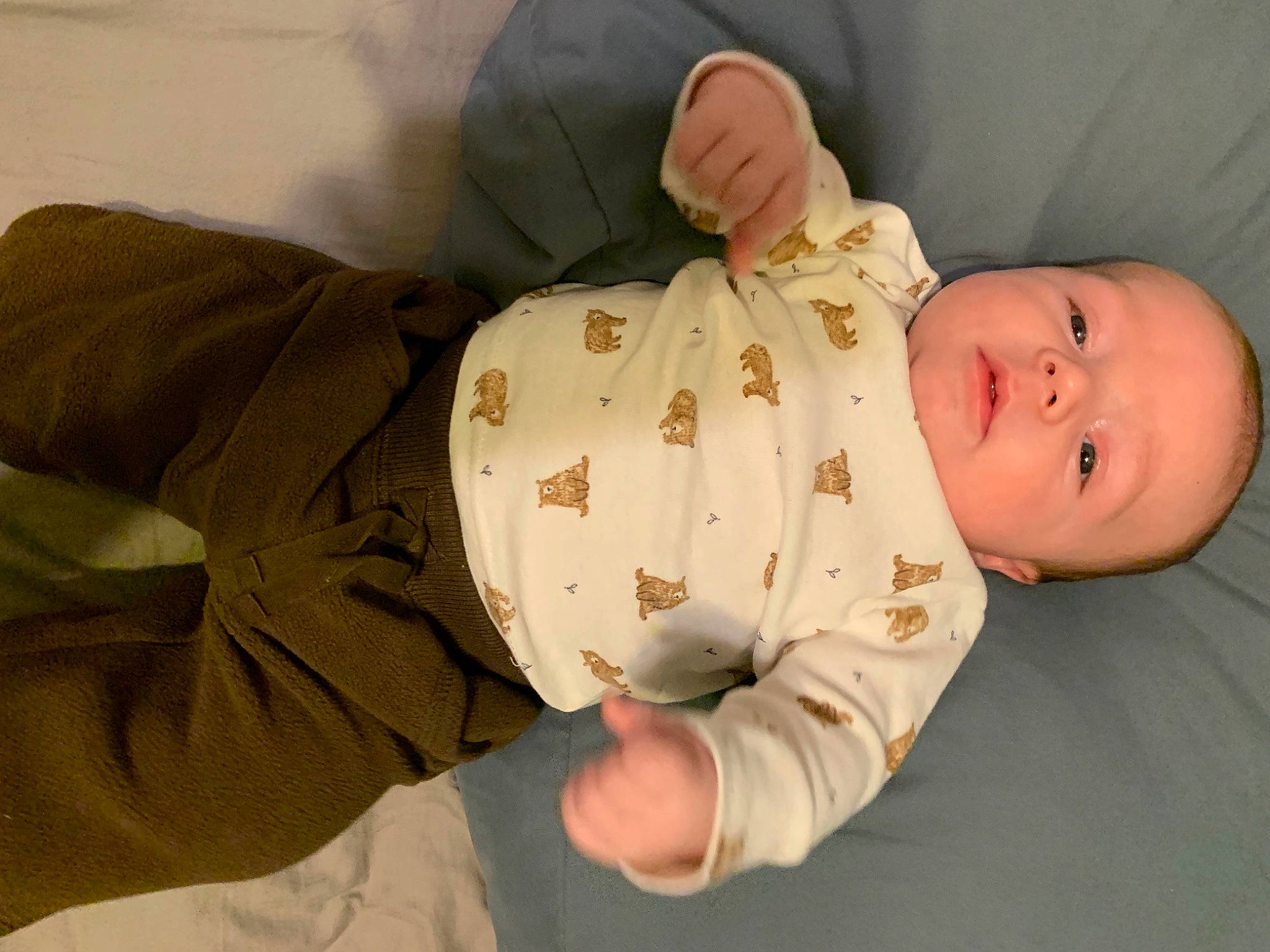 Koa is registered to the contest to win money with this photo: abdomen, baby, baby_products, baby_safety, baby_sleeping, baby_toddler_clothing, cheek, child, collar, comfort, dress_shirt, elbow, gesture, linens, person, sitting, skin, sleeve, stomach, thumb