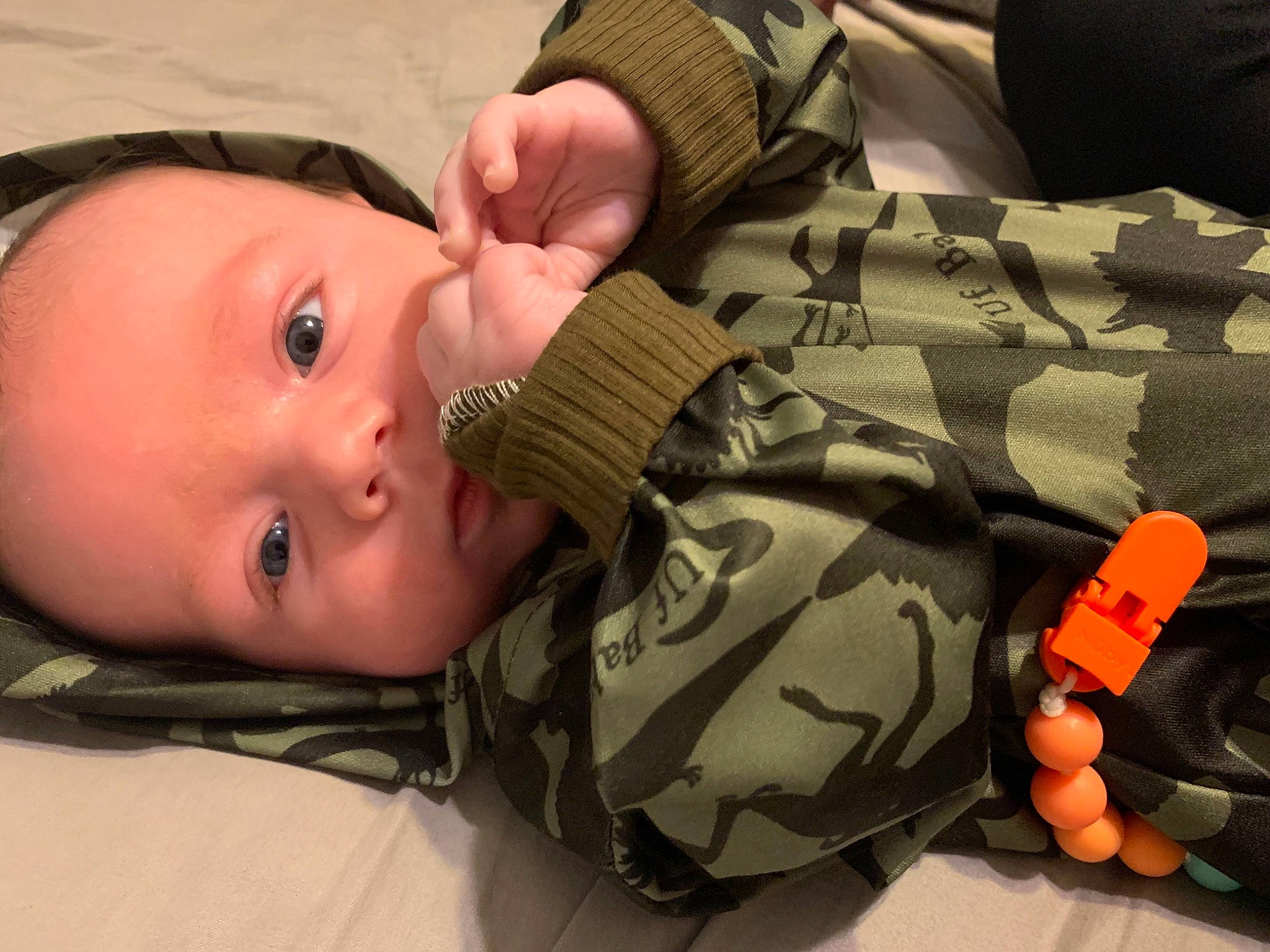 Koa is registered to the contest to win money with this photo: baby, baby_toddler_clothing, camouflage, cheek, child, comfort, eyelash, gesture, hand, human_body, military_camouflage, military_person, military_uniform, nail, pattern, person, personal_protective_equipment, soldier, thumb, toddler
