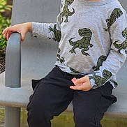 ömer Alp joined the competition — help win amazing prizes! child, boy, toddler, smiling, happy, portrait, seated, chair, playground, outdoor, dinosaur, shirt, long_sleeves, pants, sneakers, curly_hair, fashion, person, daylight, playful