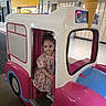 Elif is registered to the contest to win money with this photo: child, girl, toddler, face, portrait, smiling, ice_cream_truck, play_ride, amusement, indoor, mall, colorful, pink, blue, white, floral_dress, sunglasses, shoes, vehicle, ice_cream_cone