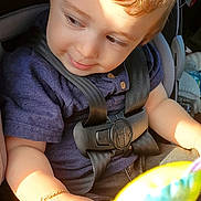 Yusuf Eren joined the competition — help win amazing prizes! toddler, child, car_seat, buckled_in,  안전, face, portrait, curious, looking_down, brown_hair, red_hair, sunlight, indoor, vehicle, toy, colorful_toy, purple_shirt, baby, sitting, photography