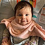 Rosemary is registered to the contest to win money with this photo: baby, infant, smiling, pink_bib, pajamas, baby_seat, cartoon, monkey, rainbow, sun, cute, child, indoor, portrait, happy, young, person, clothing, skin, hands