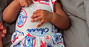 Kamarie is registered to the contest to win money with this photo: baby, bed, blanket, bow, cartoon, child, colorful, dress, eyes, family, fashion, gray, hands, indoors, infant, lying_down, photography, portrait, sitting, smiling