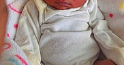 Kamarie is registered to the contest to win money with this photo: newborn, baby, sleeping, infant, portrait, face, blanket, white_clothing, onesie, bed, cozy, indoors, peaceful, relaxed, feet, hands, dark_hair, closed_eyes, photography, family