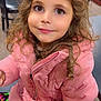 Ola joined the competition — help win amazing prizes! child, girl, curly_hair, brown_eyes, pink_jacket, puffer_jacket, smile, portrait, indoor, seated, colorful_skirt, cute, happy, person, face, warm_clothing, young, fashion, casual