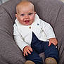 baby, child, smiling, blue_eyes, white_vest, long_sleeve_shirt, navy_pants, bean_bag_chair, indoor, happy, cute, portrait, seated, infant, hand, footwear, furniture, soft_texture, skin, person