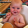 Eden participe au concours pour gagner de l'argent avec cette photo : baby, high_chair, spoon, food, messy, face, blue_eyes, skin, table, cup, smile, child, eating, indoor, person, furniture, hand, mouth, chubby, dining