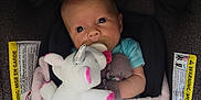 Ellie is registered to the contest to win money with this photo: baby, blanket, car_seat, child, clothing, comfort, cozy, cute, fabric, indoor, infant, newborn, pacifier, plush_toy, portrait, seatbelt, sitting, soft_toy, unicorn, warning_label