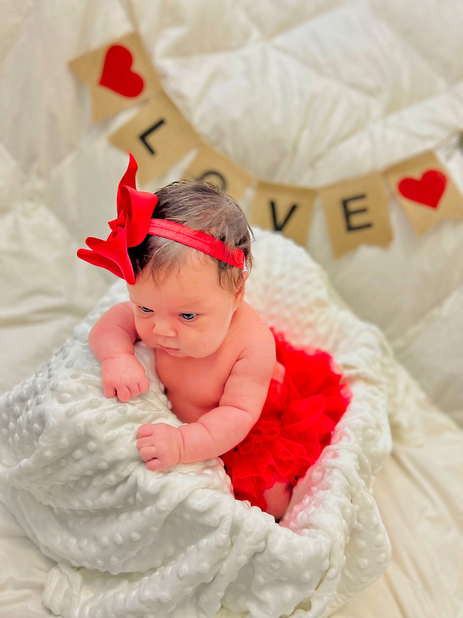 Camila is registered to the contest to win money with this photo: baby, baby_toddler_clothing, comfort, embellishment, event, face, fashion_accessory, hair_accessory, happy, head, headband, headpiece, jewellery, linens, magenta, peach, person, pink, sitting, textile