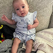 Sadie joined the competition — help win amazing prizes! baby, blanket, blue_outfit, child, clothing, comfortable, couch, cozy, curious, expression, face, hand, home, indoors, infant, legs, person, sitting, soft_texture, young
