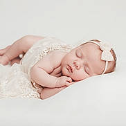 Aria participe au concours pour gagner de l'argent avec cette photo : baby, newborn, sleeping, headband, bow, lace, dress, blanket, white_background, soft_light, portrait, studio_photography, infant, peaceful, hands, feet, chubby_cheeks, pillow, lying_down, cute