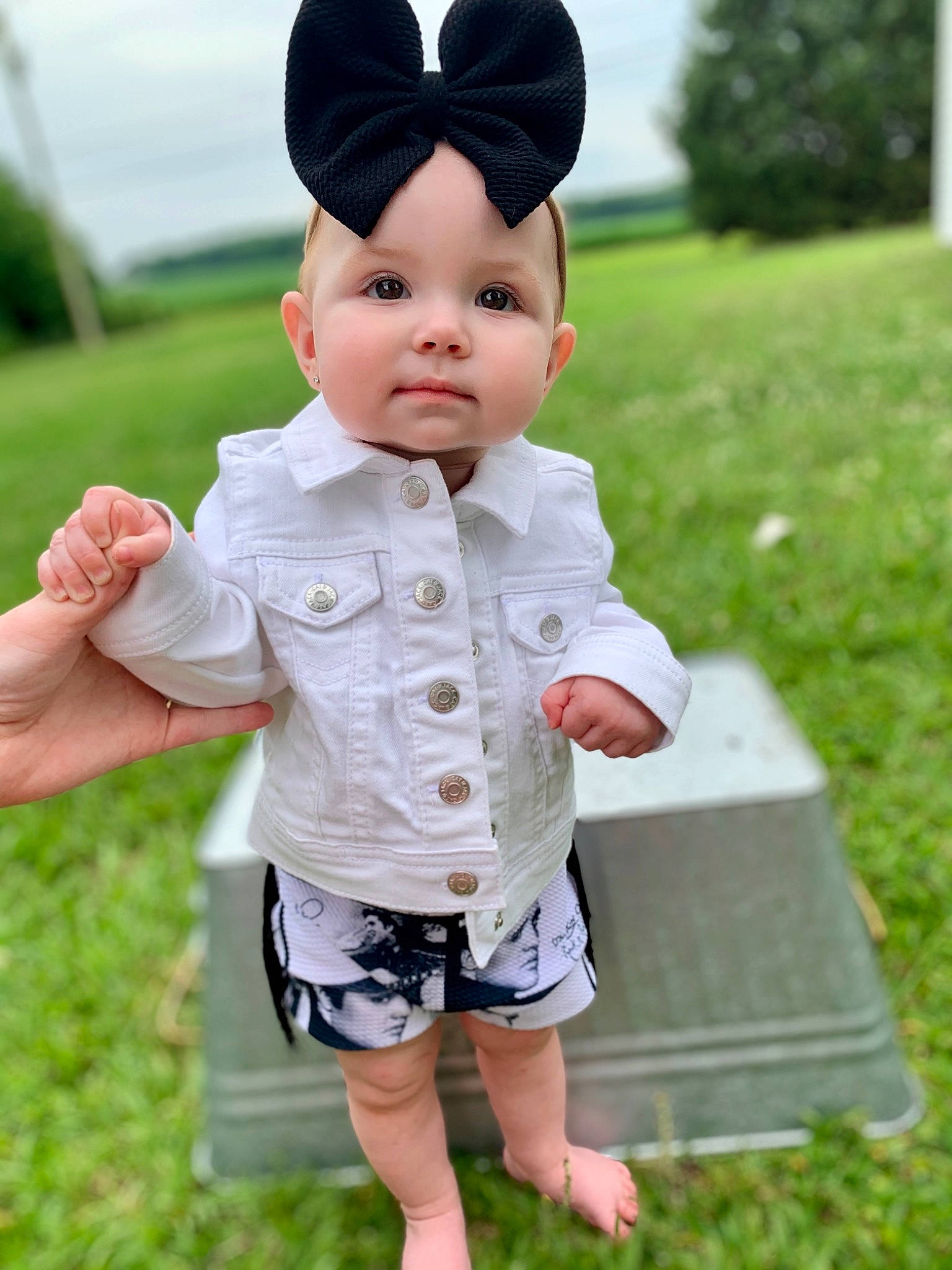 Callie-ann is registered to the contest to win money with this photo: cap, child, doll, fun, gesture, grass, hand, happy, headwear, joint, leisure, people_in_nature, person, pink, shorts, skin, sleeve, street_fashion, toddler, toy