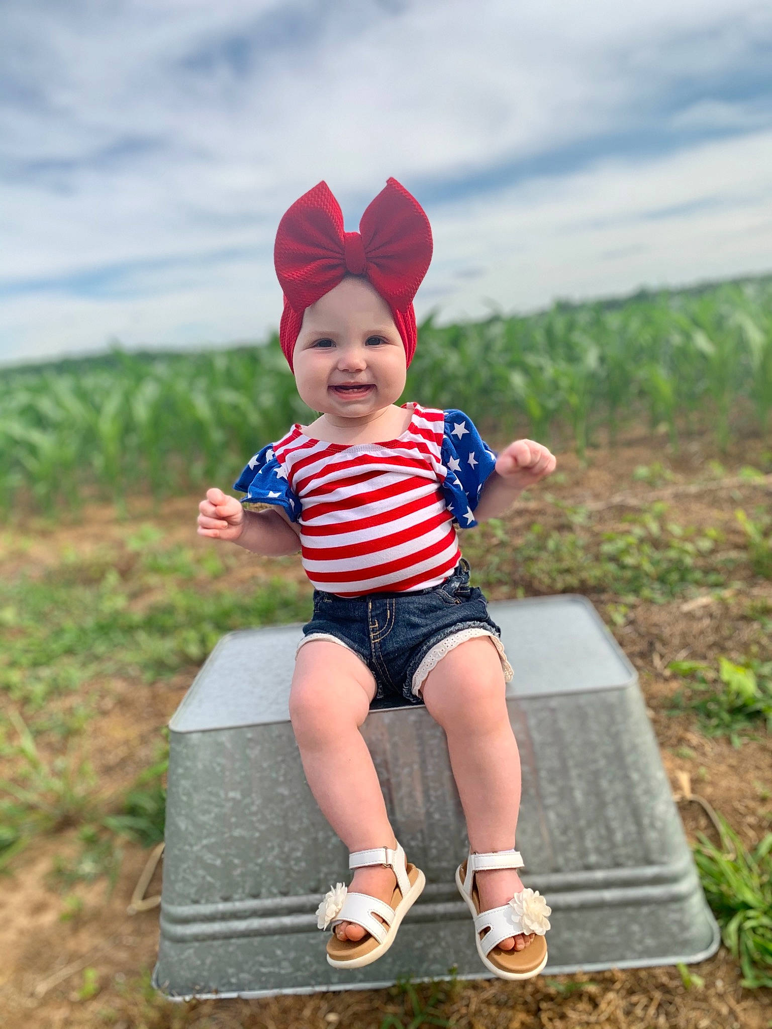 Callie-ann is registered to the contest to win money with this photo: baby, baby_toddler_clothing, child, cloud, costume_hat, electric_blue, fun, grass, grassland, happy, headwear, human_leg, joy, pattern, people_in_nature, person, plant, sitting, sky, smile