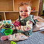 baby, child, toy, carpet, indoor, smile, cute, play, colorful, block, green, purple, pink, clothing, vest, socks, face, person, happy, floor