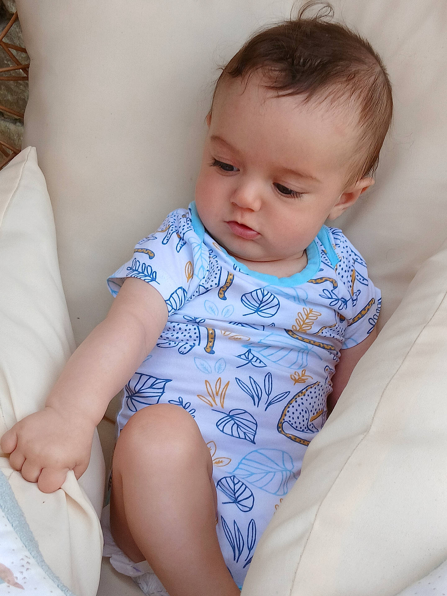 Mathys participe au concours pour gagner de l'argent avec cette photo : baby, child, clothing, comfort, curious, cushion, expression, face, hair, hand, head, indoor, infant, leg, onesie, person, sitting, skin, soft, white