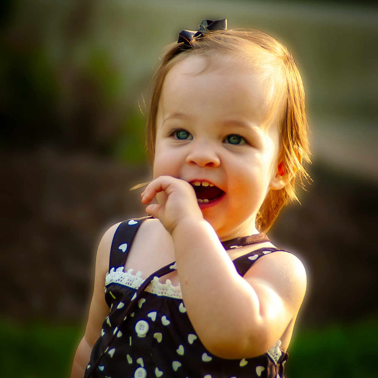 Journee is registered to the contest to win money with this photo: black_dress, child, clothing, cute, dress, garden, girl, green_eyes, happy, hearts_pattern, light_hair, nature, outdoor, person, portrait, smiling, summer, sunlight, toddler, young_child