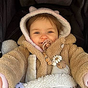 Adèle participe au concours pour gagner de l'argent avec cette photo : baby, child, pacifier, jacket, hood, blanket, stroller, smile, cute, warm_clothing, beads, wooden_clip, face, portrait, infant, cozy, soft_texture, fur, happy, outdoor