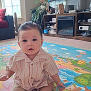 Erick joined the competition — help win amazing prizes! baby, carpet, child, colorful, curious, cute, floor, furniture, home, indoor, living_room, person, plant, play_mat, portrait, sitting, striped_shirt, television, toy, young_child