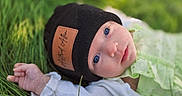 Astrid joined the competition — help win amazing prizes! baby, beanie, bodypart, bonnet, cap, clothing, face, finger, glove, grass, hand, happy, hat, head, newborn, person, photography, plant, portrait, smile