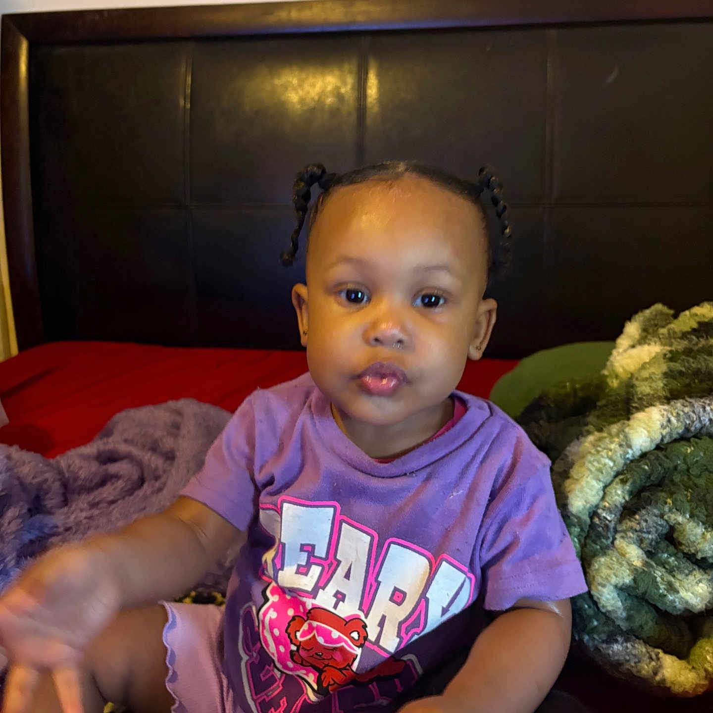 𝓣𝓪𝓶𝓪𝓻𝓪 joined the competition — help win amazing prizes! baby, child, toddler, portrait, sitting, bed, bedroom, blanket, pillow, braids, pigtails, purple_shirt, graphic_shirt, infant, face, eyes, lips, indoor, furniture, cozy