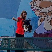 Choupette a rejoint le concours — aidez-le/la à gagner de superbes lots ! person, dog, bench, mural, graffiti, outdoor, gravel, wall, art, throwing, red_shirt, black_and_white_dog, colorful, park, grass, nature, casual, young_adult, activity, street_art