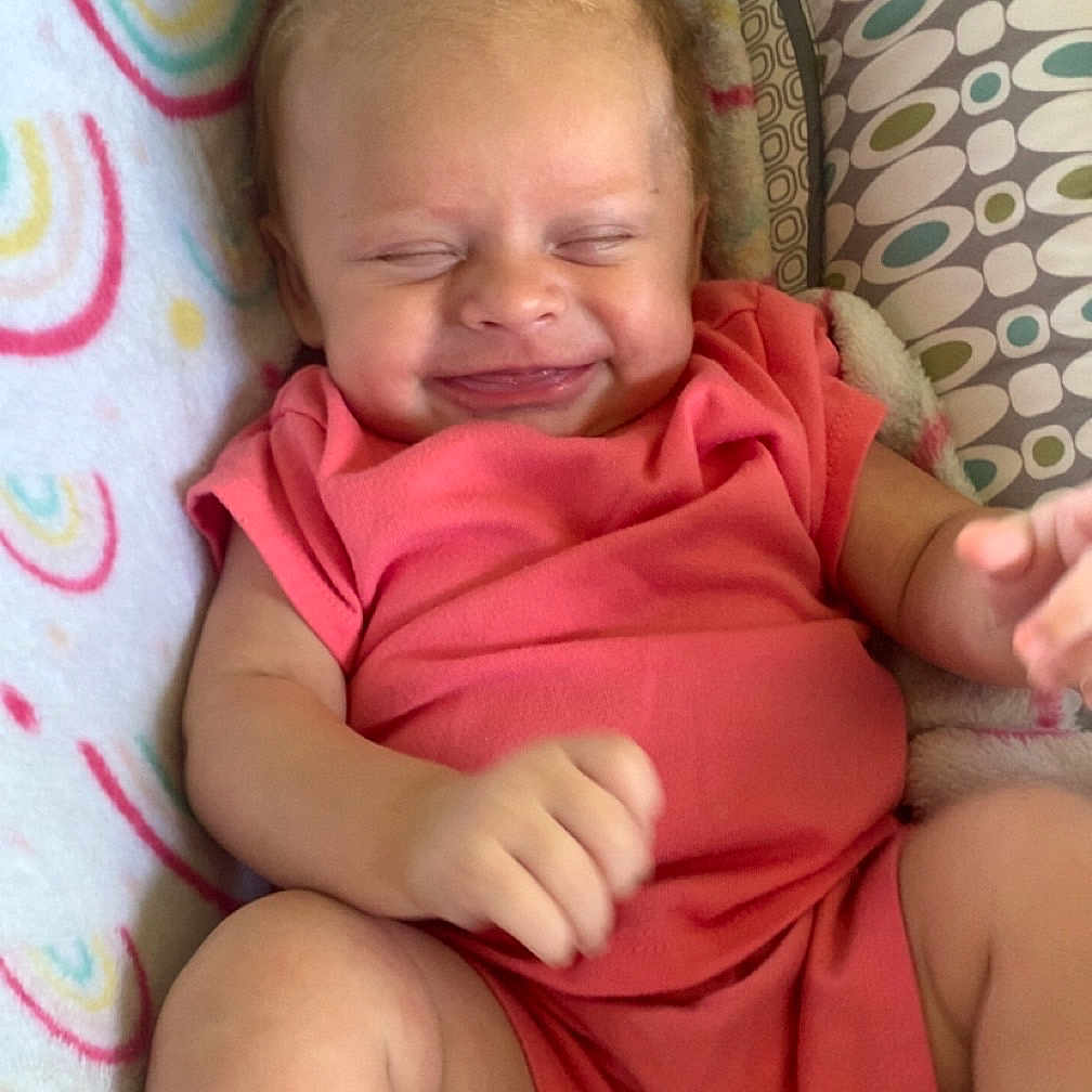 Henleigh joined the competition — help win amazing prizes! baby, blanket, child, cozy, cute, face, hand, happy, head, indoors, infant, leg, lying_down, pacifier, pink_clothing, rainbow_pattern, relaxed, skin, small_hair_tie, smiling