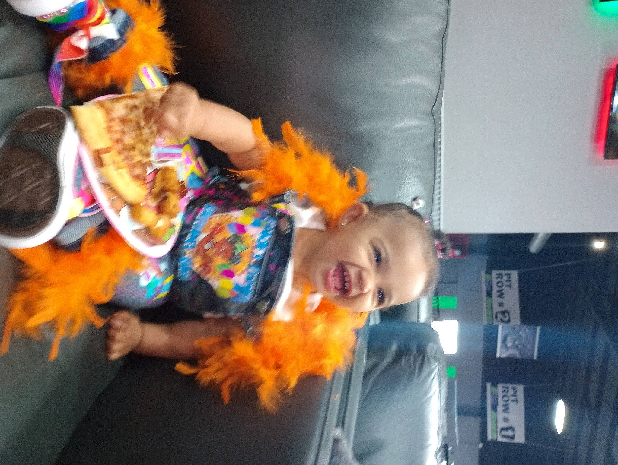 Danasia is registered to the contest to win money with this photo: animation, costume, entertainment, event, feather_boa, festival, fun, fur, happy, hat, orange, person, public_event, smile, toddler