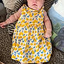 Zoé a rejoint le concours — aidez-le/la à gagner de superbes lots ! baby, carpet, cherry_pattern, child, clothing, cute, dress, expression, face, feet, home, indoor, infant, laying, person, pillow, skin, soft, texture, yellow