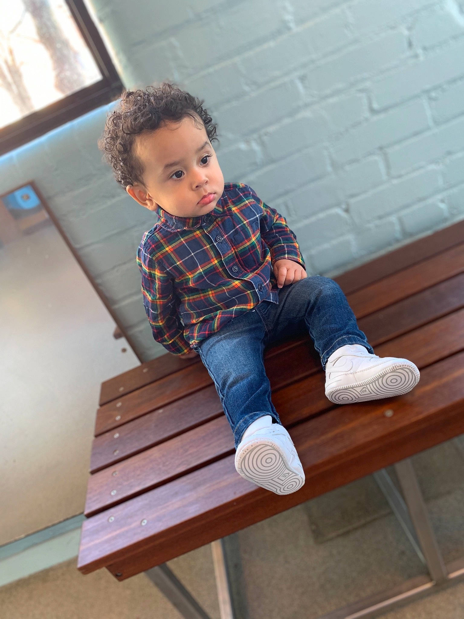 Jovanni is registered to the contest to win money with this photo: arm, clothing, denim, dress_shirt, furniture, jeans, joint, knee, leg, leisure, outdoor_furniture, person, plaid, product, shoulder, sleeve, stairs, standing, t_shirt, tartan