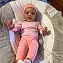 baby, clothing, crib, face, furniture, hat, head, hosiery, infantbed, person, sitting, sleeve, sock